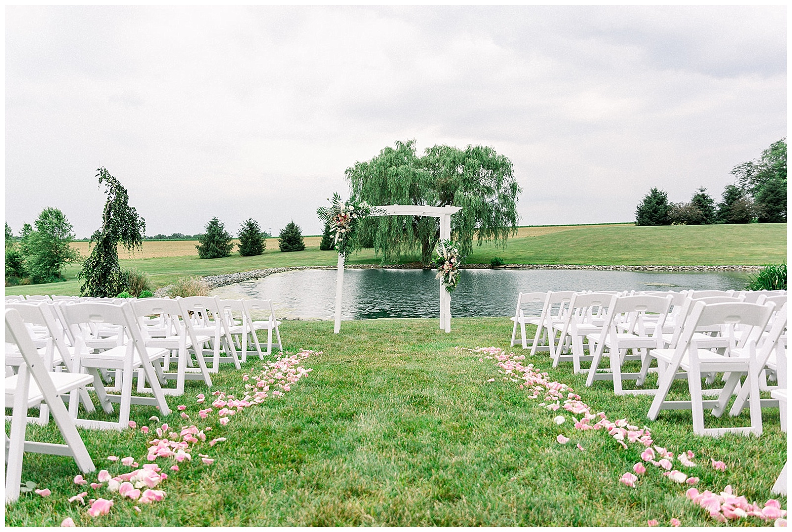 ceremony is set up by the lake at lakefield weddings, a modern barn wedding venue
