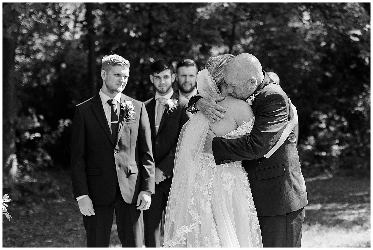 brides father gives her a hug at the end of the aisle